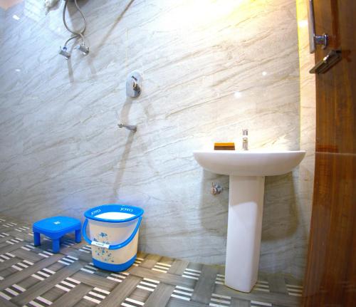 a bathroom with a sink and a bucket at MAHARANI Hotel in Khatīma