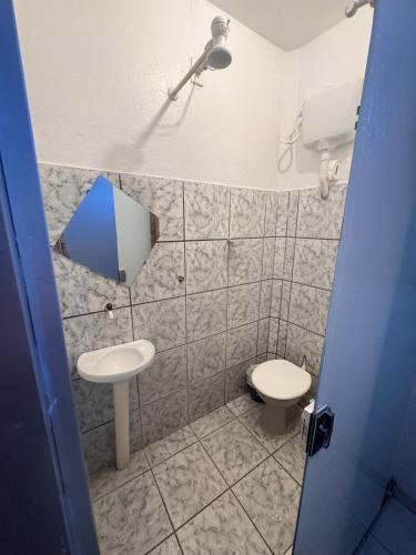 a small bathroom with a toilet and a sink at Pousada Torre dos Mouros in Pirenópolis