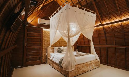 a bedroom with a bed with a mosquito net at Permata Hill Nusa Penida in Nusa Penida