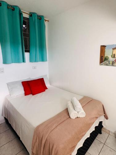 a bedroom with a bed with two towels on it at Pousada Torre dos Mouros in Pirenópolis