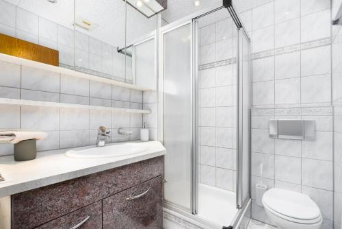 a bathroom with a shower and a toilet and a sink at Maisonette-Apartment mit großer Terrasse im Zentrum von Bregenz in Bregenz