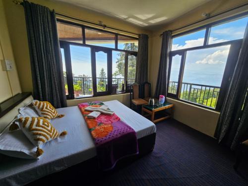 a bedroom with a bed and a large window at Smarthill-Green Forest View in Dalhousie