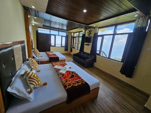 two beds in a room with large windows at Smarthill-Green Forest View in Dalhousie