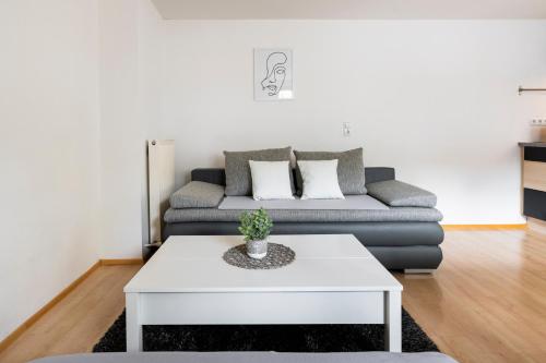 a living room with a couch and a white coffee table at Maisonette-Apartment mit großer Terrasse im Zentrum von Bregenz in Bregenz