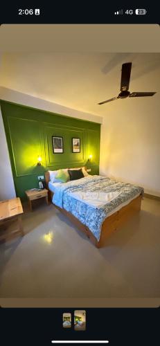 a bedroom with a bed with a green wall at Snong-Gree Motel and Restaurant in Rupa