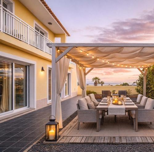 a patio with a table and chairs and a pergola at Villa dos Anjos in Porto Santo