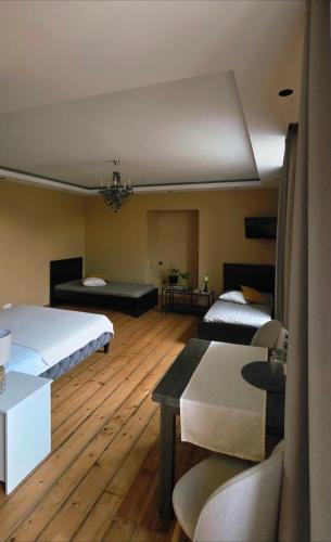 a large room with two beds and a table at Dundagas rezidence in Dundaga
