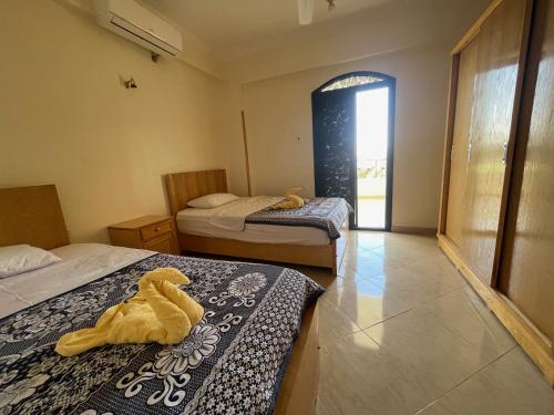 a room with two beds and a yellow duck on the bed at Sunflower in Al Aqālitah
