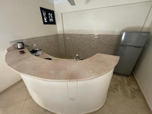 a large bath tub in a bathroom with a refrigerator at Sunflower in Al Aqālitah