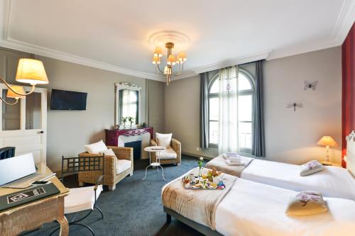 a hotel room with two beds and a living room at Cristal Hôtel Restaurant in Saumur