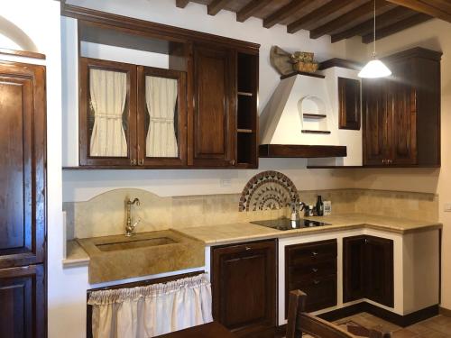 a kitchen with wooden cabinets and a sink at Casa Varna in Gambassi Terme