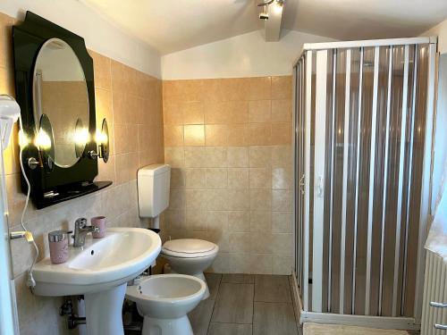 ein Badezimmer mit Waschbecken, Toilette und Spiegel in der Unterkunft BeB Le Masere in Madonna di Fornelli