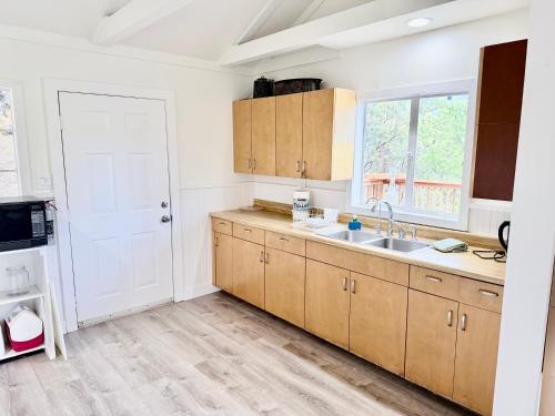 a kitchen with wooden cabinets and a sink at Wishon Cabin - Boat Slip - BBQ, Sleeps 14, Dogs Ok in The Pines