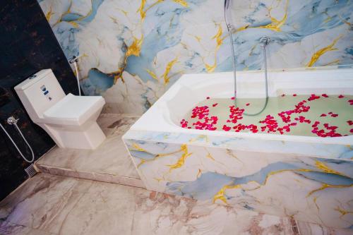 a bathroom with a toilet and a bath tub at Kheya Tori Resort in Tajpur