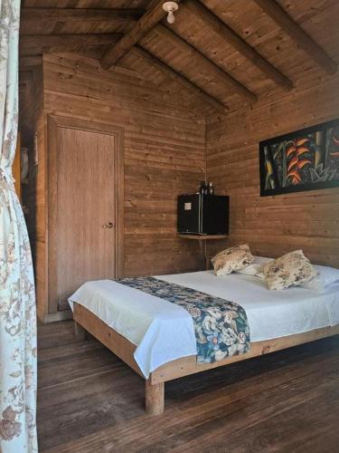 a bedroom with a bed in a wooden wall at La Chorrera ecohotel in Cocorná