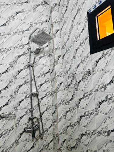 a shower in a bathroom with marble tiles at Villa Diamaguene in Ngaparou