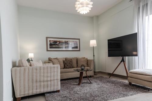 a living room with a couch and a flat screen tv at Volos Comfort Stay with free parking in Volos