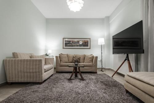 a living room with a couch and a flat screen tv at Volos Comfort Stay with free parking in Volos