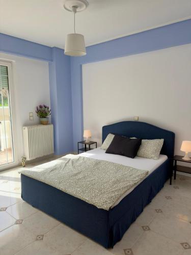 a bedroom with a large bed with blue walls at Meltemi Evia in Paralía