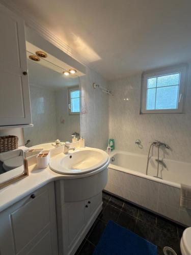 a white bathroom with a sink and a tub at Meltemi Evia in Paralía