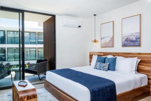a bedroom with a large bed and a balcony at Mono Luxe Villas in Tamarindo