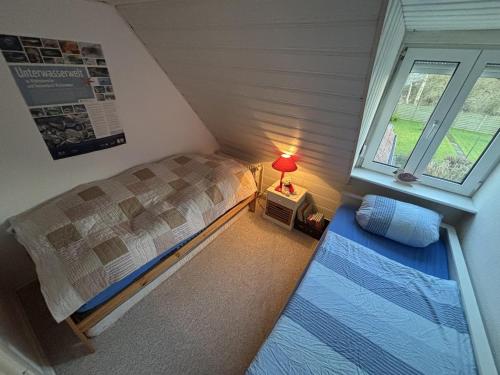 a small bedroom with a bed and a window at Ferienhaus Husum Nordsee in Husum