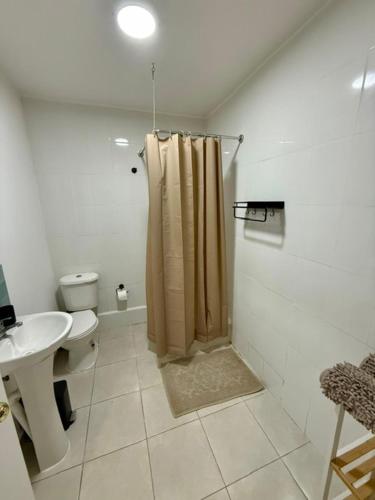 a bathroom with a shower and a toilet and a sink at Casa Hostal , Mejillones in Mejillones