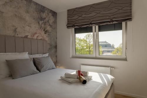 a bedroom with a large white bed with two windows at Luxury Opus Osijek - Self Check in, Free Private Parking in Osijek