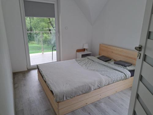 a bedroom with a bed and a large window at U Znajomych in Wołkowyja