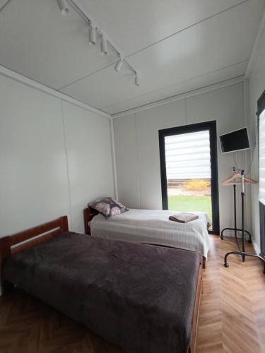 a bedroom with two beds and a window at Pas Alksnius in Rotuliai