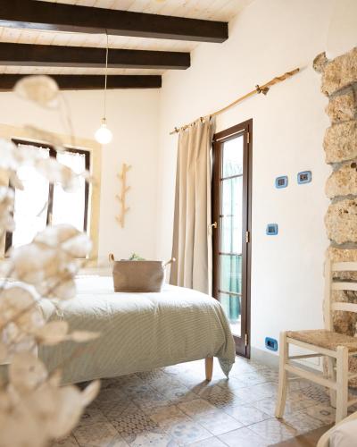 a bedroom with a bed and a chair at Agriturismo Alveare in Finale Ligure