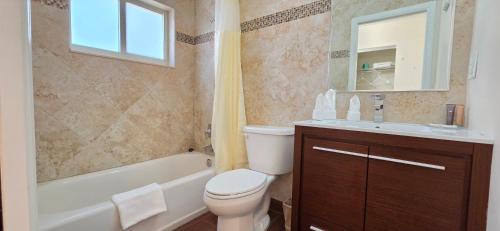 a bathroom with a toilet and a tub and a sink at Curtis Inn & Suites in Hollywood