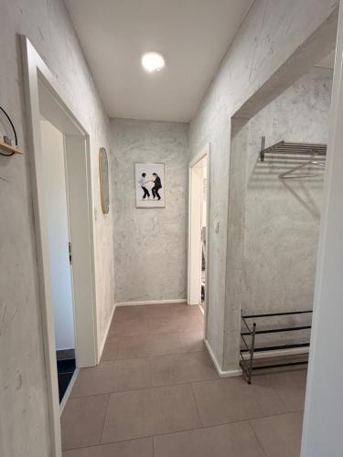 a hallway with a tile floor and a white wall at City-Apartment Leimbach in Siegen