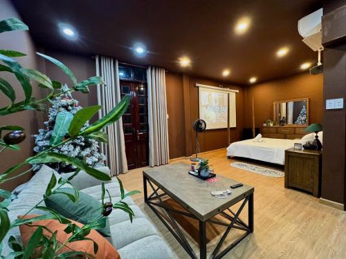 a living room with a bed and a table at Uh Homestay Thảo Điền in Ho Chi Minh City