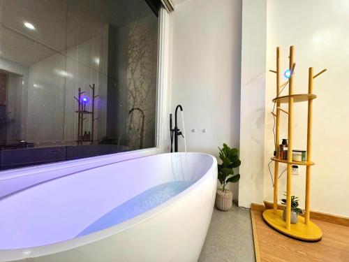 a white bath tub in a bathroom with a window at Uh Homestay Thảo Điền in Ho Chi Minh City