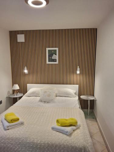 a bedroom with a large bed with towels on it at Apartments Villa Bazilika in Sečovlje