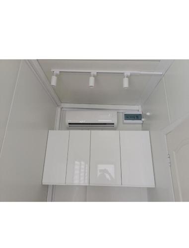 a kitchen with white cabinets and a ceiling at Pas Alksnius in Rotuliai
