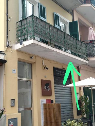 a building with a balcony with a green x on it at Appartamento Centrale - sulla pedonale in Dolceacqua