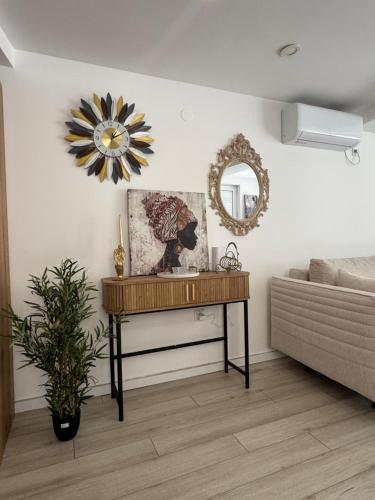 a living room with a table and a mirror at Mille in Igalo