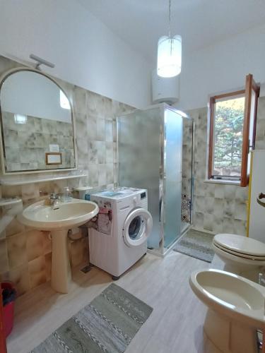 a bathroom with a washing machine and a sink at Villa Panorama in Lipari