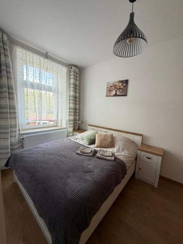 a bedroom with a bed and a large window at Apartment between the bridges in Zgorzelec