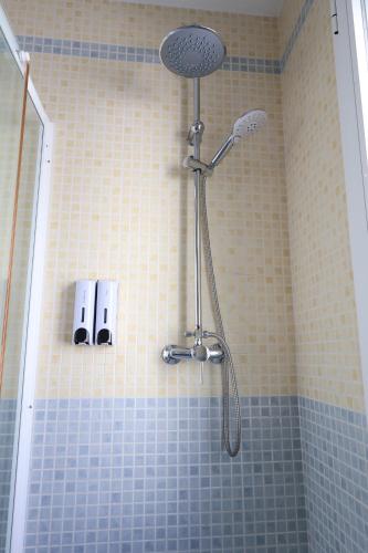a shower in a bathroom with blue tiles at Paseo Imperial in Arcos de la Frontera