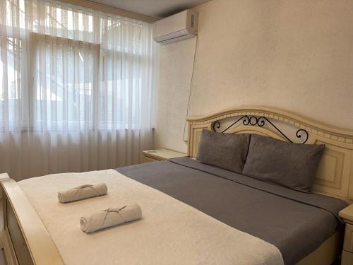 a bedroom with a large bed with two slippers on it at Prishtina Guests in Prishtinë