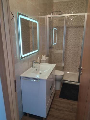 a bathroom with a sink and a toilet and a mirror at Jardim da Guarda Inglesa in Santa Clara