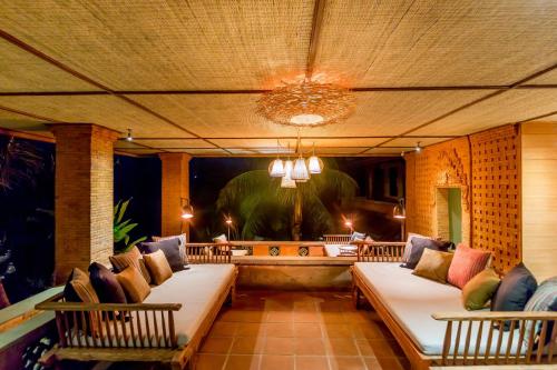 a porch with two beds and two chairs at Ulun Ubud Resort - CHSE Certified in Ubud