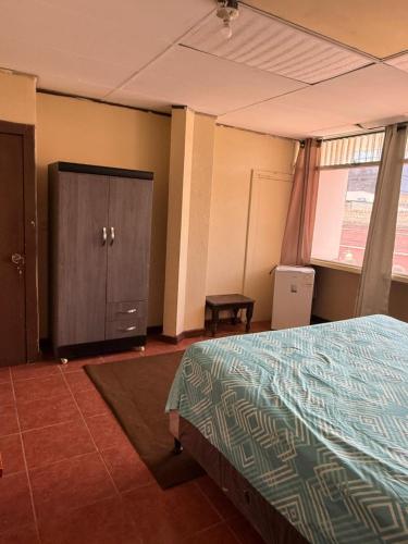 a bedroom with a bed and a cabinet and a window at casa zona 10 in Lo de Contreras