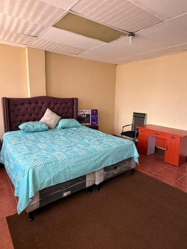 a bedroom with a large bed and a desk at casa zona 10 in Lo de Contreras