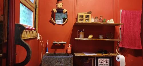 a room with an orange wall with a shelf at Quinta Maravista in Faial da Terra