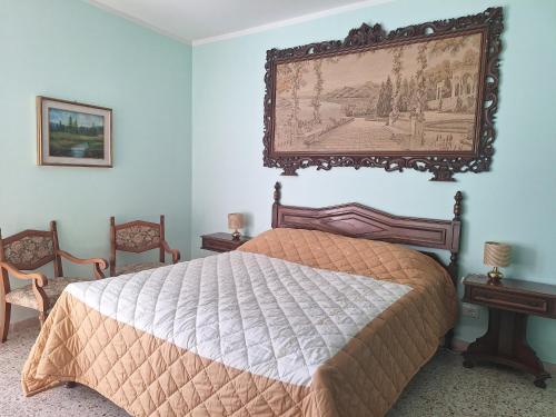a bedroom with a bed with a picture on the wall at La Cuccia del Sole Panoramische appartementen met zwembad in Cortemilia