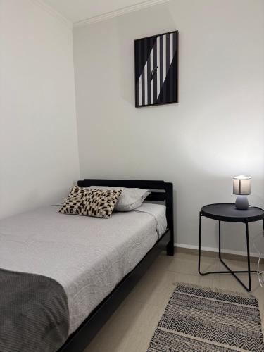 a bedroom with a bed with a table and a picture at Casa Hostal , Mejillones in Mejillones